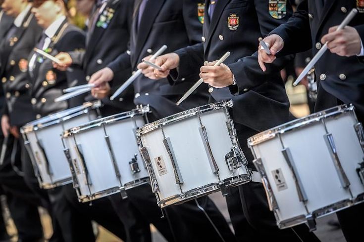Tight drumline snare crop showing traditional grip and white snare shells