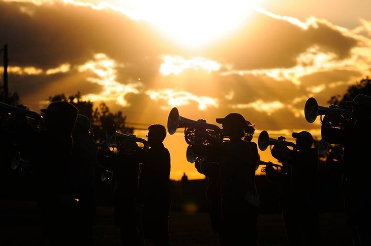 Lincolnview brass line silhouetted dramatically against sunset rehearsal sky