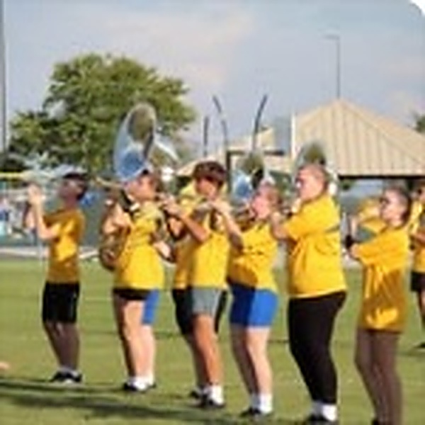 Lincolnview brass section marching in bright yellow shirts outdoors
