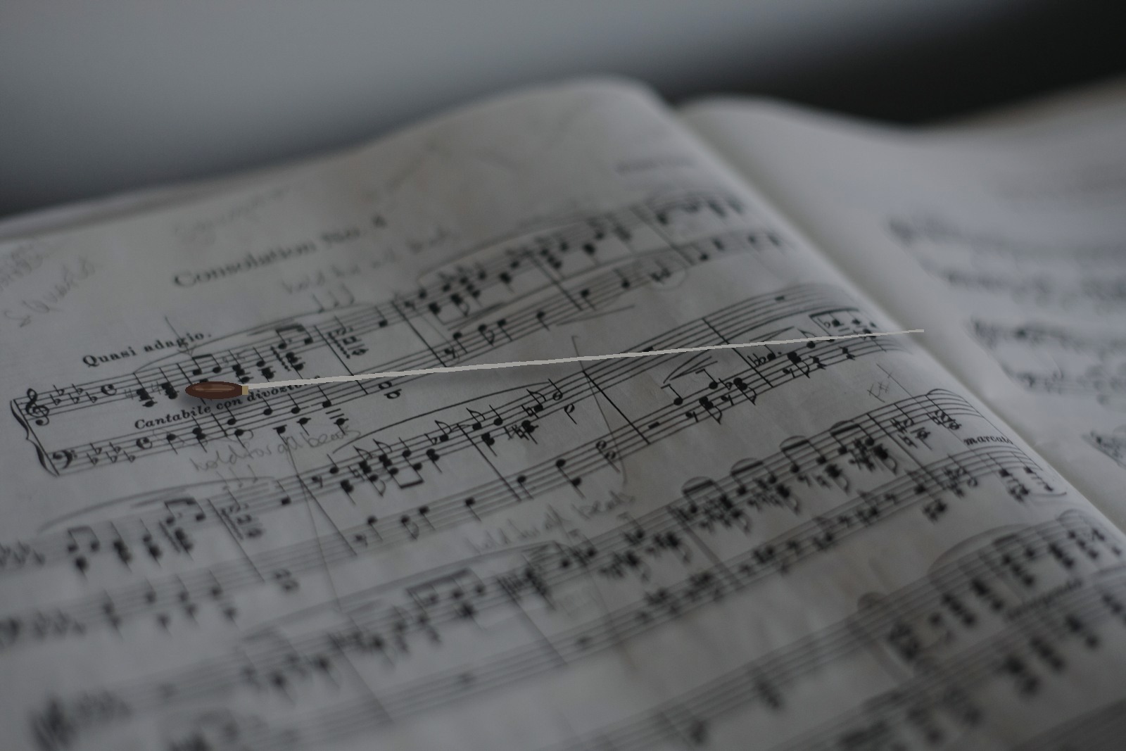Close-up of conductor's baton resting on musical score